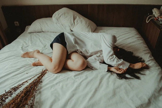 Mujer con dolor acostada en una cama