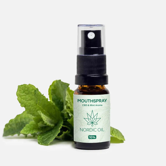 Spray bucal de CBD con aroma a menta de Nordic Oil, botella ámbar con atomizador negro y hojas de menta alrededor
