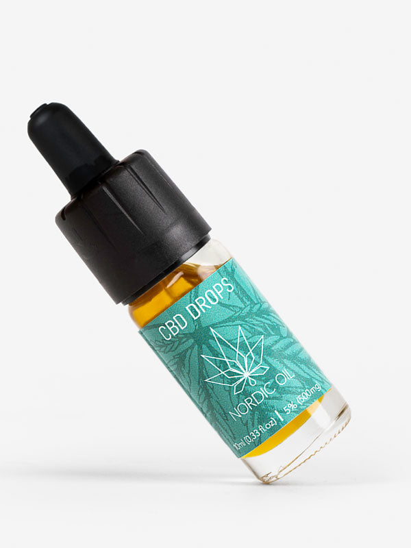 Una botella de aceite de CBD (5%) se encuentra en diagonal en el borde izquierdo.