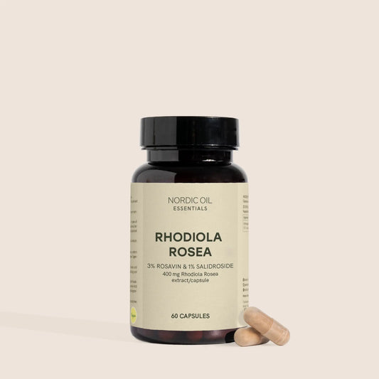 Botella de cápsulas Rhodiola Rosea de Nordic Oil Essentials con dos cápsulas a su lado.