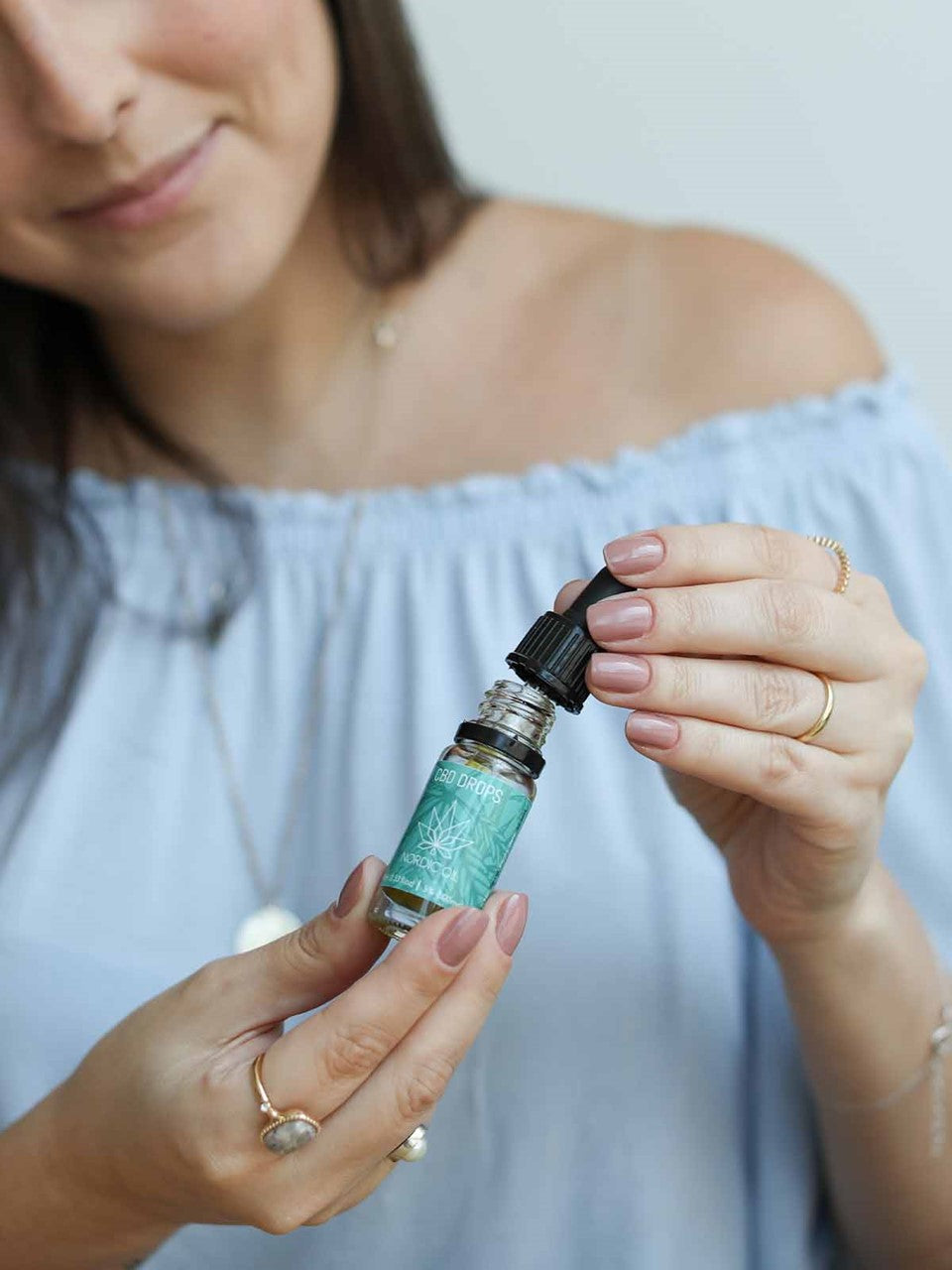 Mujer sosteniendo un frasco de CBD con gotero