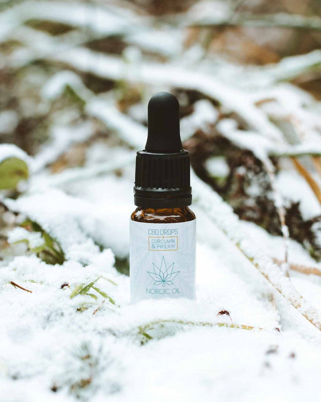 Frasco de Nordic Oil CBD Drops con gotero en la nieve.