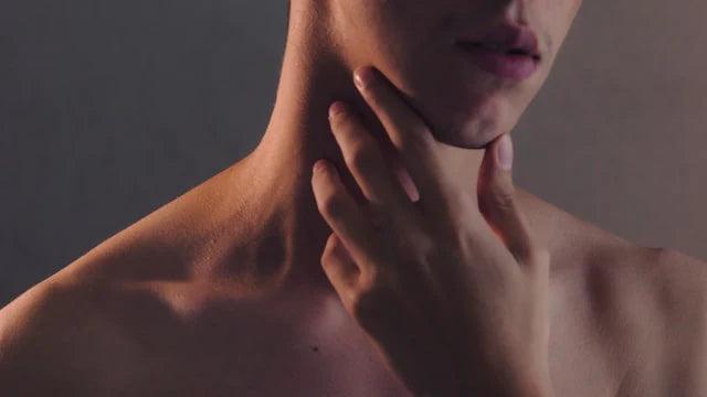 persona alcanzando hacia su cuello donde se encuentra la glándula tiroides