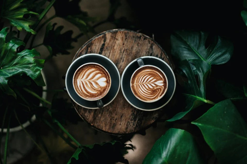 Dos tazas de café sobre una mesa de madera.