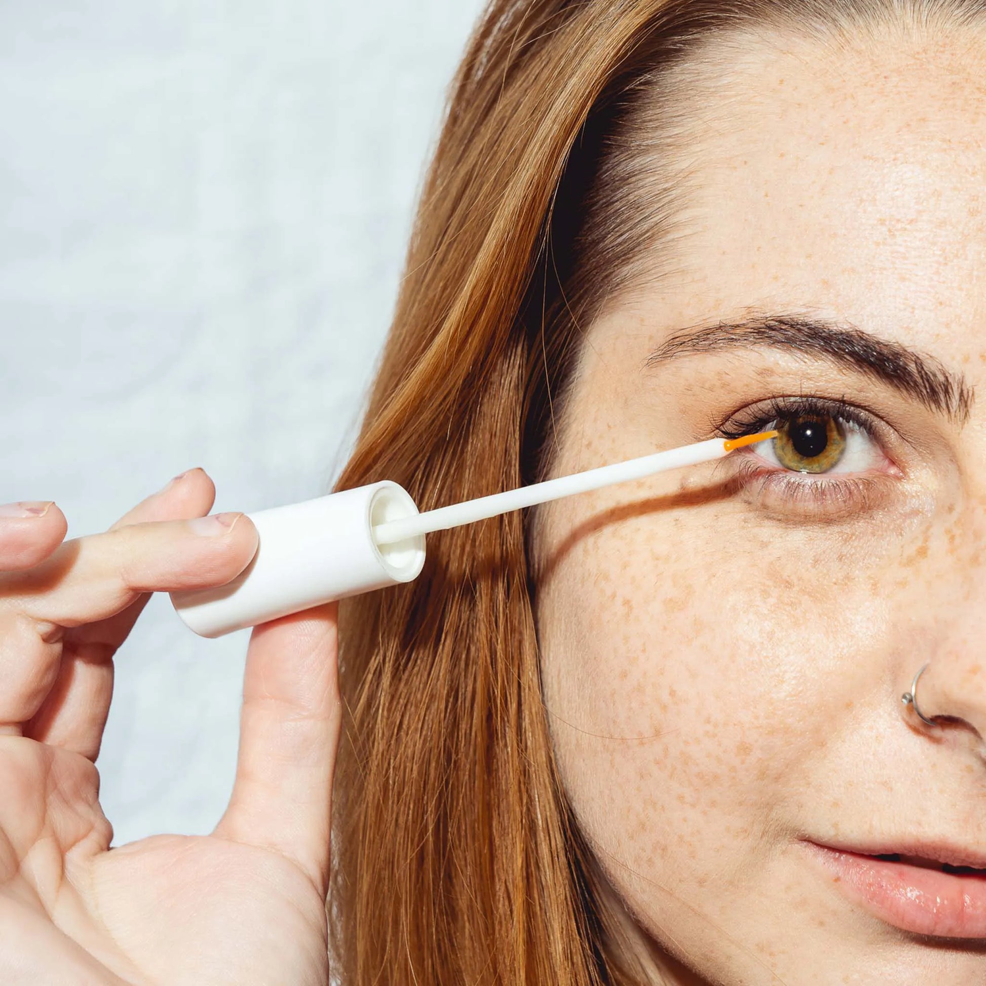 una mujer sostiene el suero delante del ojo