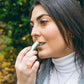 Una mujer se aplica Bálsamo labial de CBD en los labios.