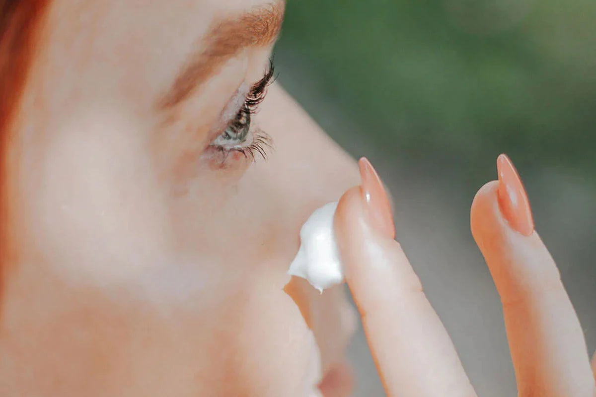 Una mujer se aplica Crema de Noche - CBD & Vitamina E en la cara. 