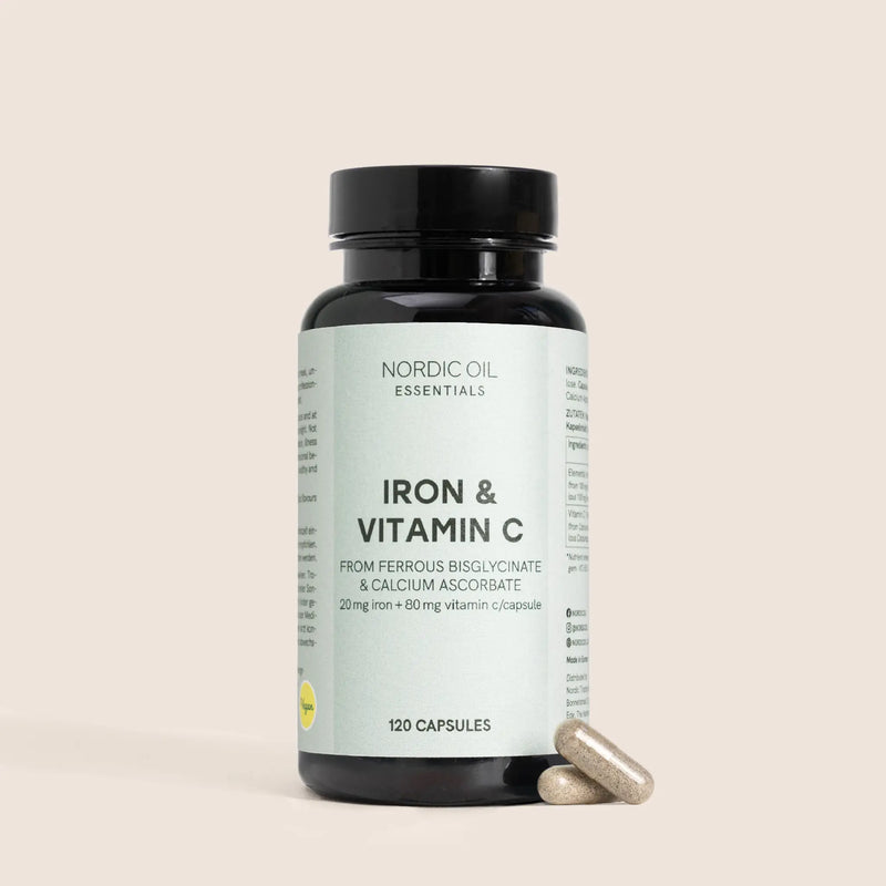 Botella oscura de Nordic Oil Essentials Iron & Vitamin C con cápsulas a su lado