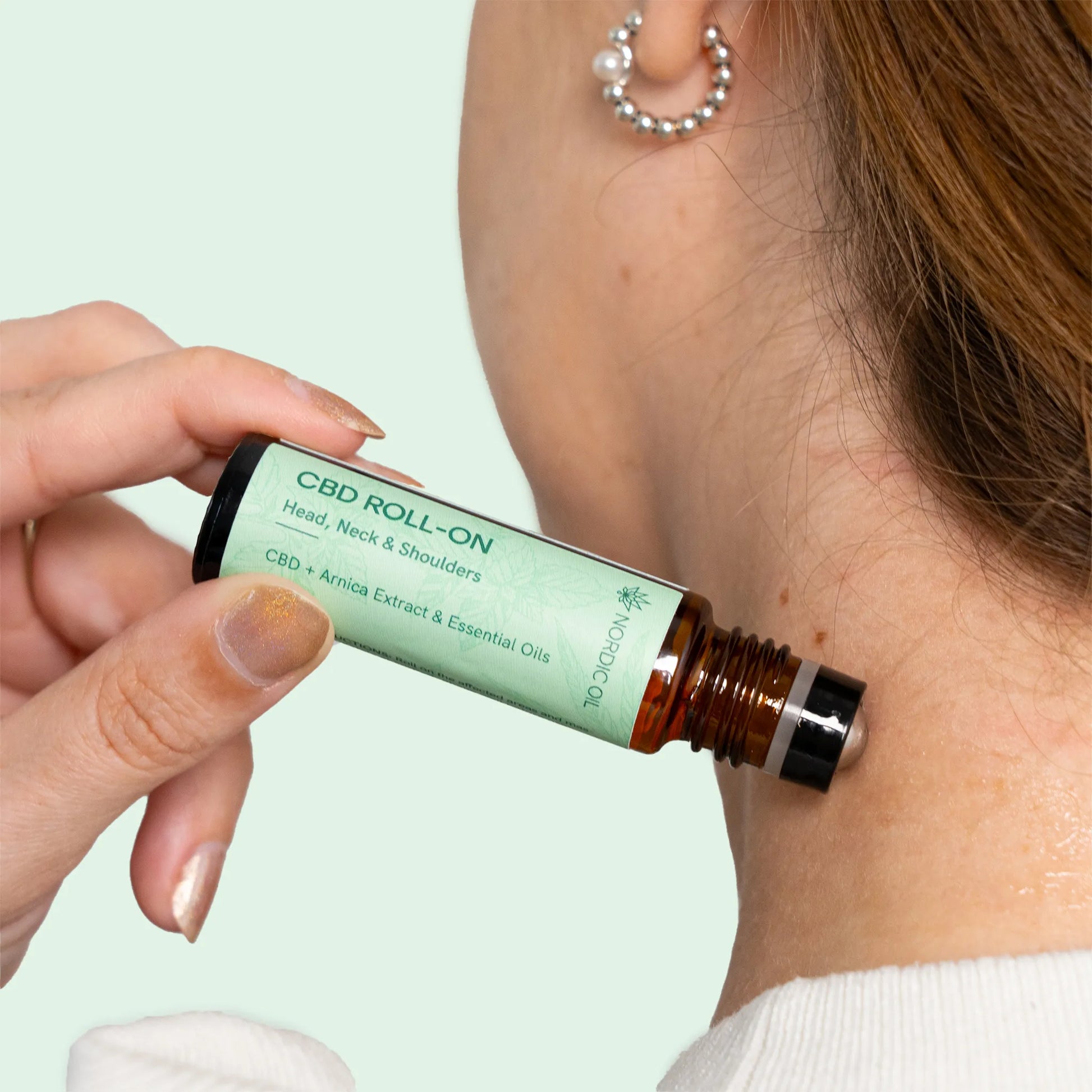 una mujer utiliza el cbd roll on de nordic oil 