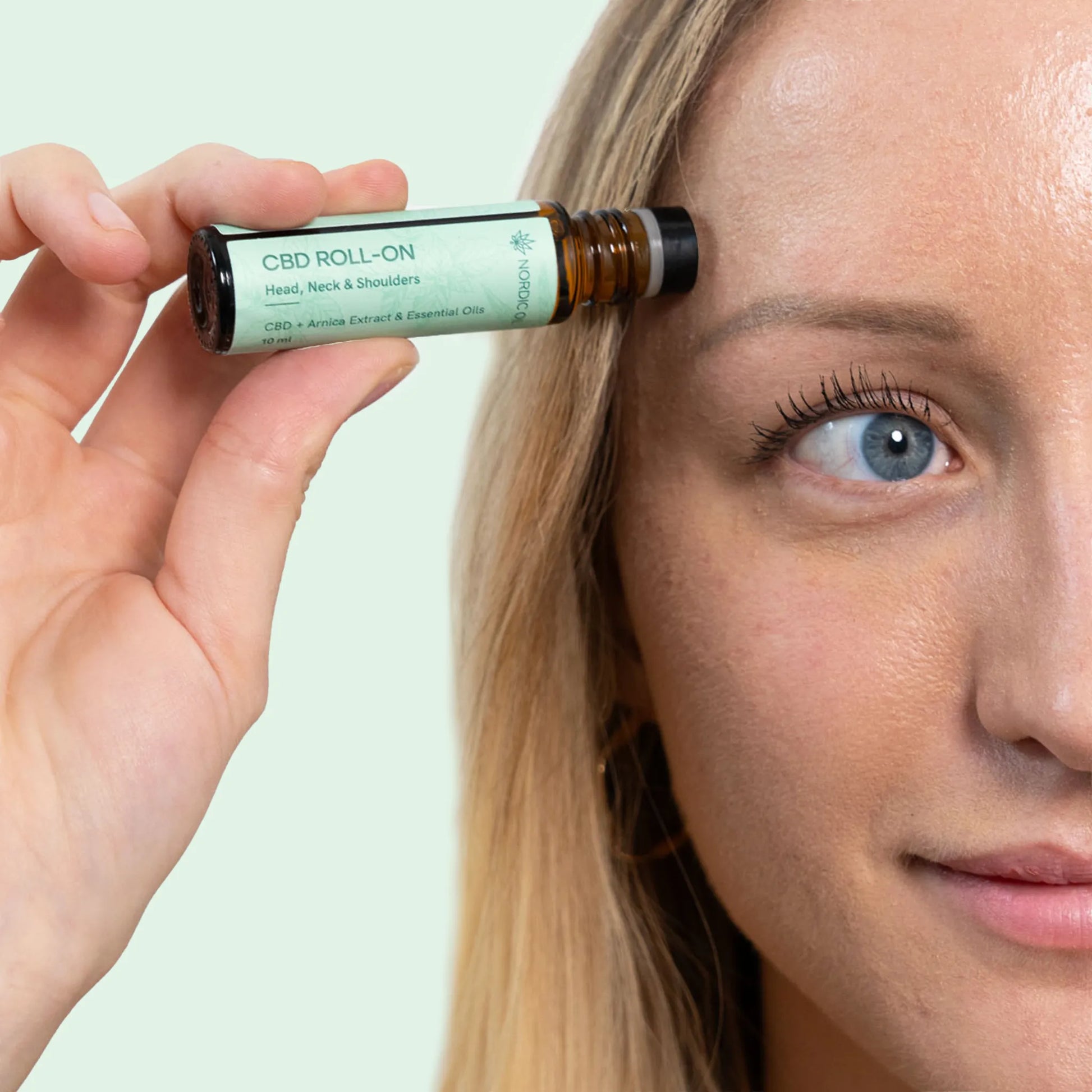 una mujer utiliza el cbd roll on de nordic oil 