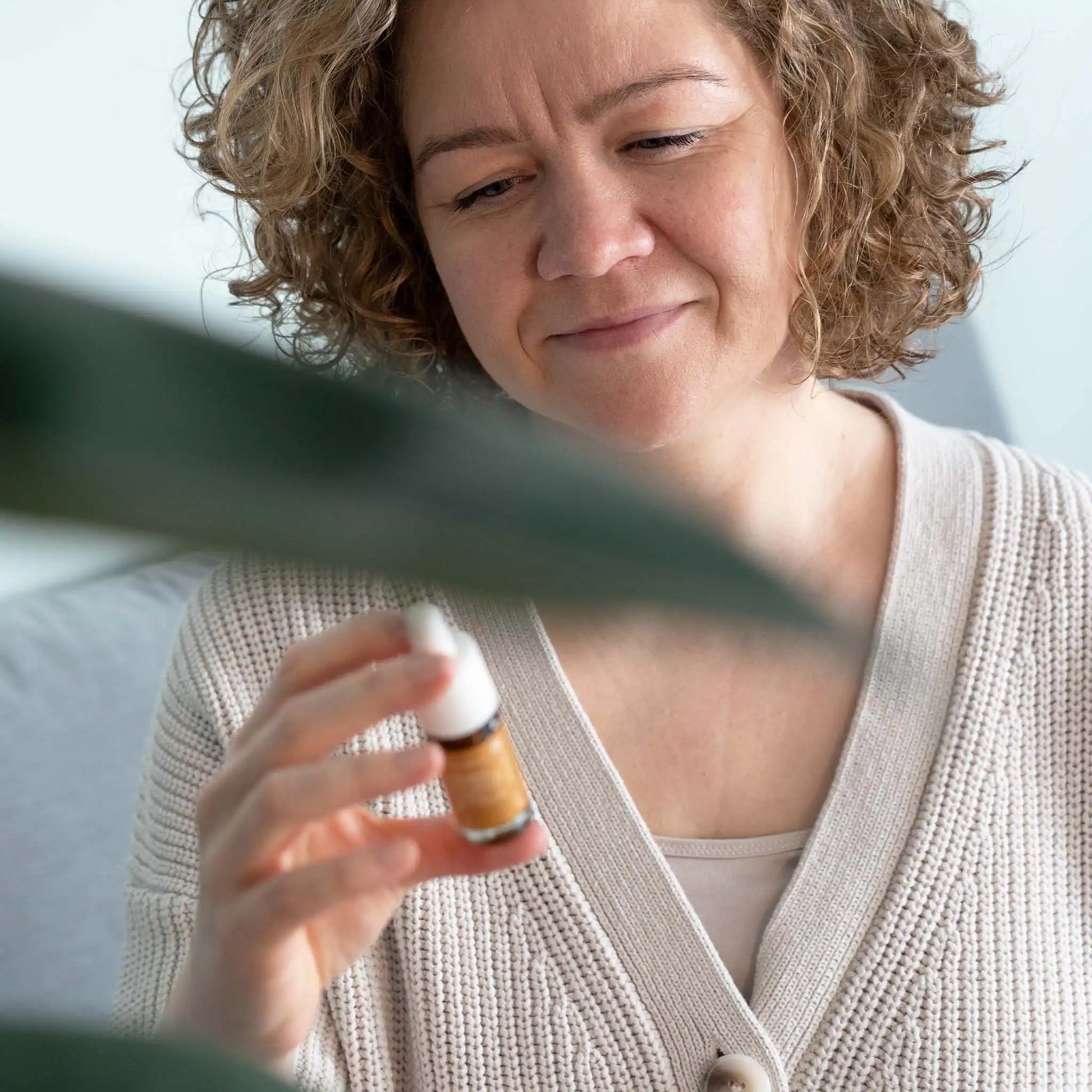 Una mujer sostiene una botella de aceite de CBD de amplio espectro con curcumina