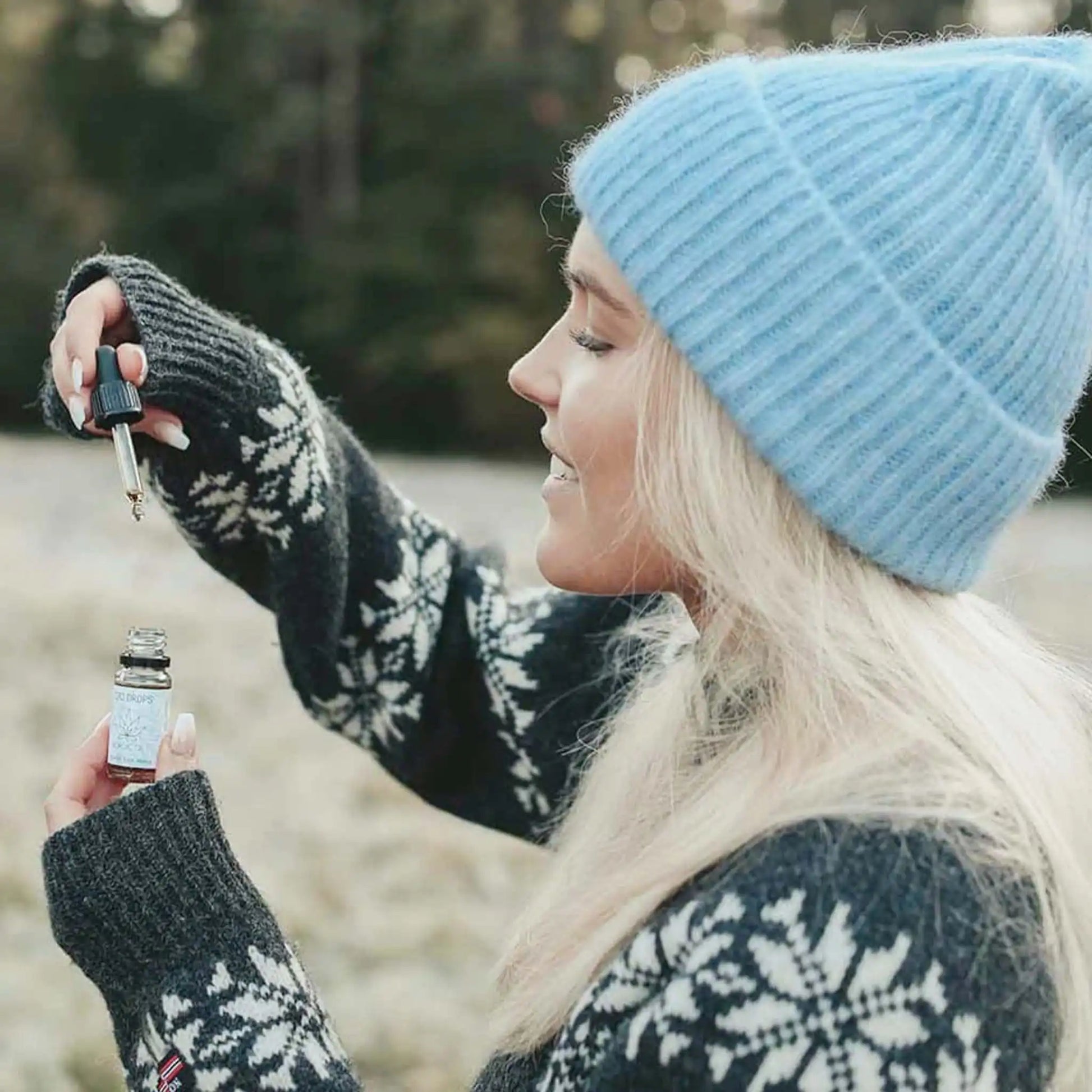 Una mujer sosteniendo un frasco abierto de 10 ml de aceite de CBD 15% de amplio espectro
